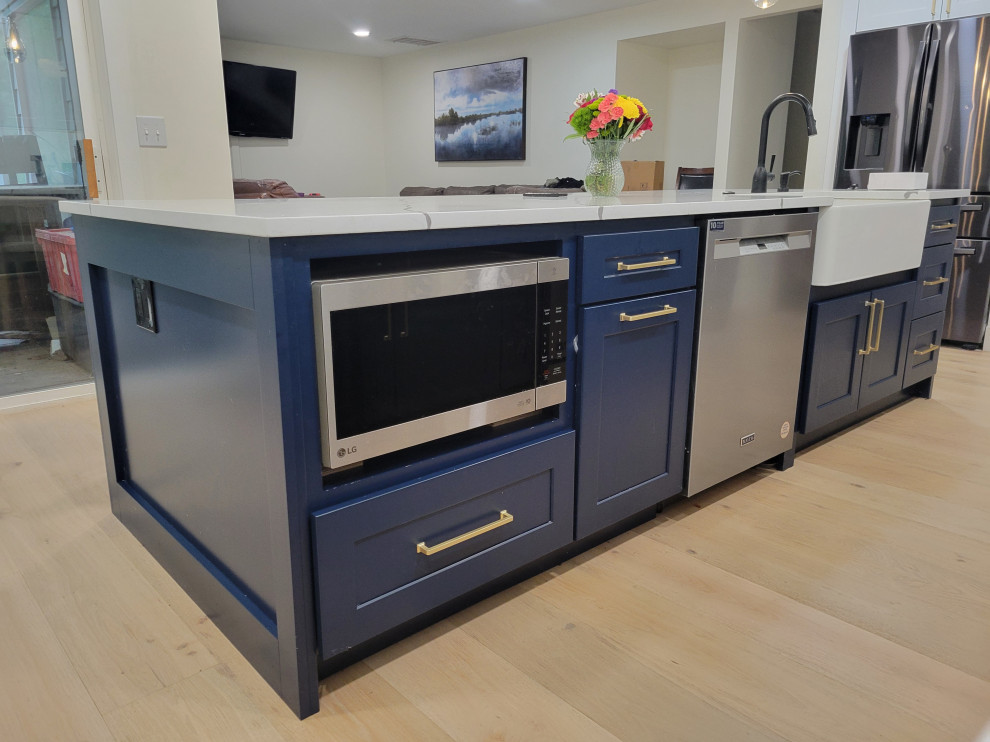 Inspiration for a mid-sized brown floor eat-in kitchen remodel in Seattle with blue cabinets, quartzite countertops, white backsplash, quartz backsplash, stainless steel appliances, an island and white countertops