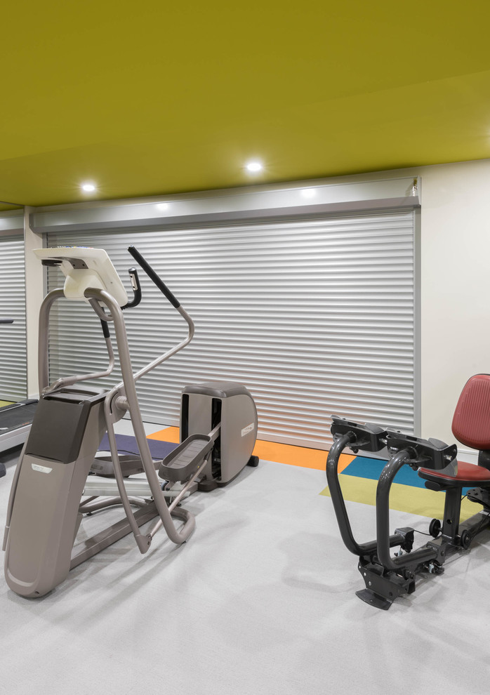 Photo of a large contemporary home weight room in Toronto with white walls, carpet and multi-coloured floor.