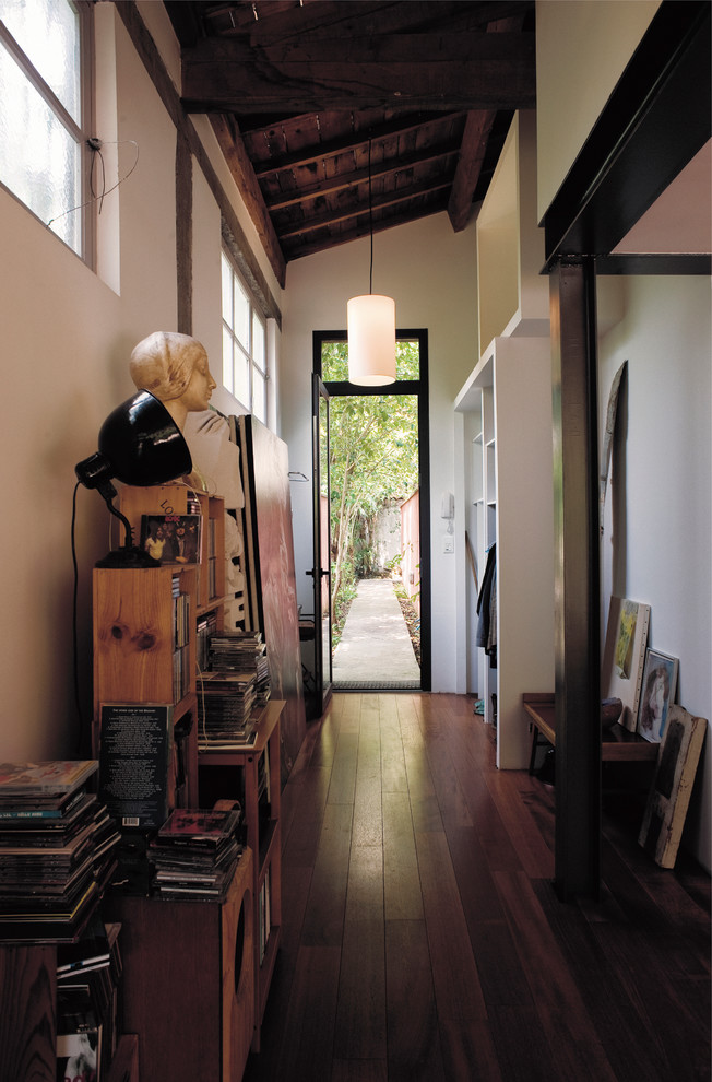 Photo of a mid-sized eclectic hallway in Toulouse with white walls and dark hardwood floors.