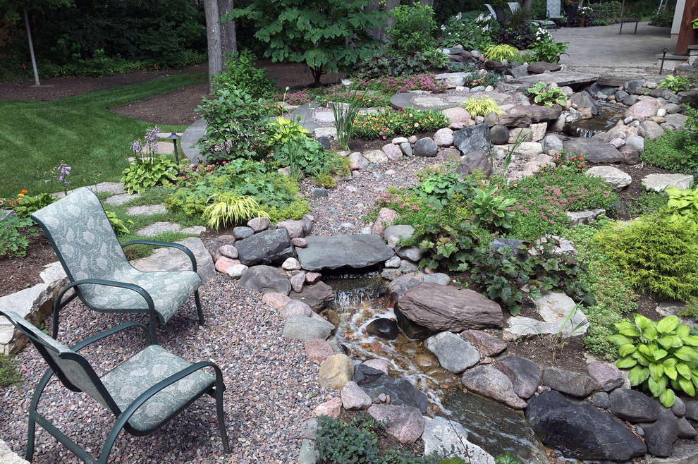 Design ideas for a mid-sized arts and crafts backyard partial sun garden for summer in Chicago with a water feature and natural stone pavers.