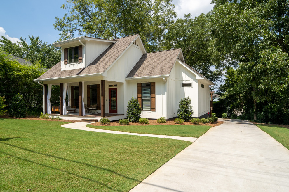 Photo of a small country one-storey white exterior in Atlanta with vinyl siding, a gable roof, a shingle roof, a brown roof and board and batten siding.