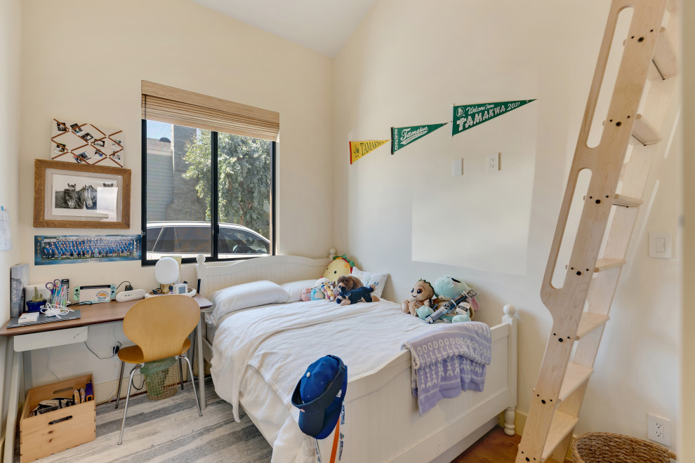 Idee per una piccola cameretta per bambini moderna con pareti bianche, pavimento in legno massello medio, pavimento marrone e soffitto a volta