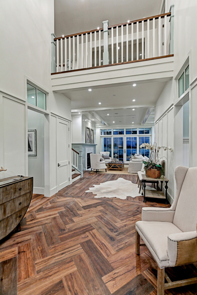 This is an example of an expansive country foyer in Los Angeles with white walls and medium hardwood floors.