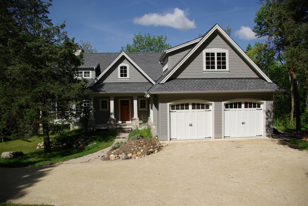 Photo of a mid-sized traditional two-storey grey exterior in Milwaukee with wood siding and a gable roof.