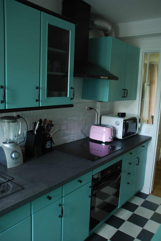 Photo of a small midcentury galley separate kitchen in Paris with a double-bowl sink, raised-panel cabinets, green cabinets, laminate benchtops, white splashback, subway tile splashback, black appliances, ceramic floors and no island.