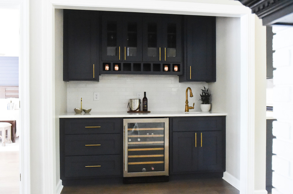 Inspiration for a mid-sized transitional wet bar in Charlotte with a drop-in sink, shaker cabinets, blue cabinets, quartzite benchtops, white splashback, brick splashback, dark hardwood floors, multi-coloured floor and white benchtop.