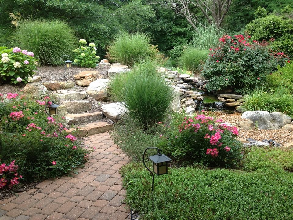 Design ideas for a mid-sized backyard stone water fountain landscape.
