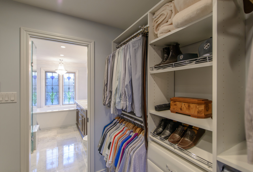 Inspiration for a mid-sized traditional gender-neutral walk-in wardrobe in Toronto with flat-panel cabinets, white cabinets and dark hardwood floors.