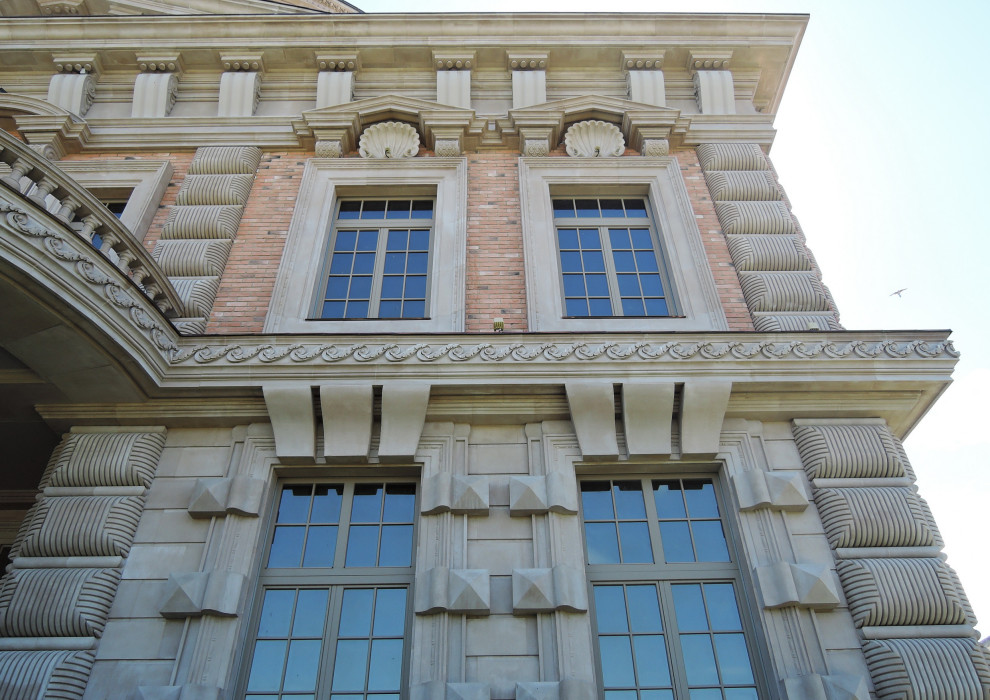 Modelo de fachada de casa beige y marrón clásica grande de tres plantas con revestimiento de piedra, tejado plano y tejado de metal