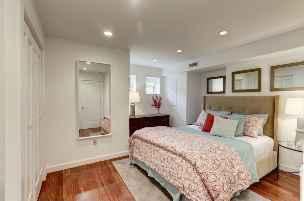 Inspiration for a mid-sized master bedroom in DC Metro with white walls, medium hardwood floors, no fireplace and red floor.