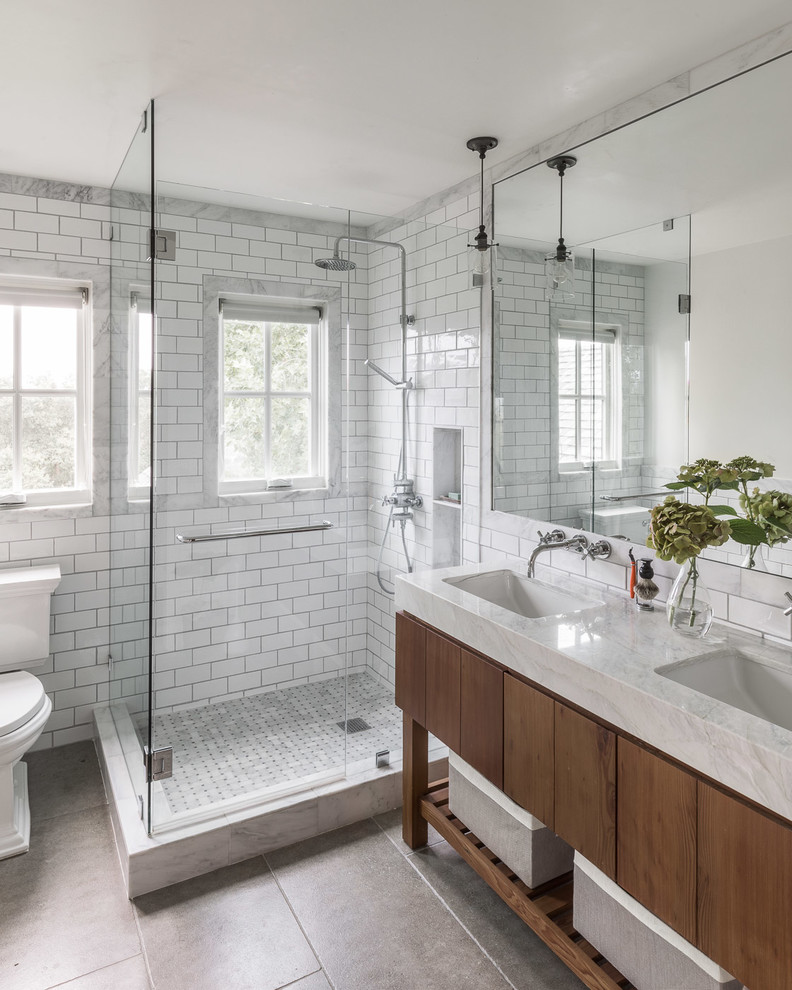 Inspiration for a country master bathroom in San Francisco with flat-panel cabinets, dark wood cabinets, a corner shower, a two-piece toilet, white tile, subway tile, white walls, an undermount sink, grey floor, a hinged shower door and white benchtops.