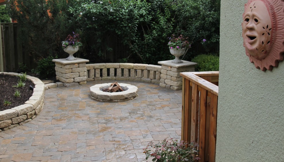 Small traditional backyard patio in Kansas City with a fire feature and concrete pavers.