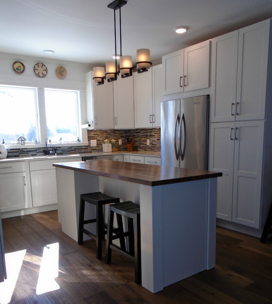 Inspiration for a mid-sized transitional u-shaped eat-in kitchen in Grand Rapids with shaker cabinets, white cabinets, solid surface benchtops, stainless steel appliances and with island.