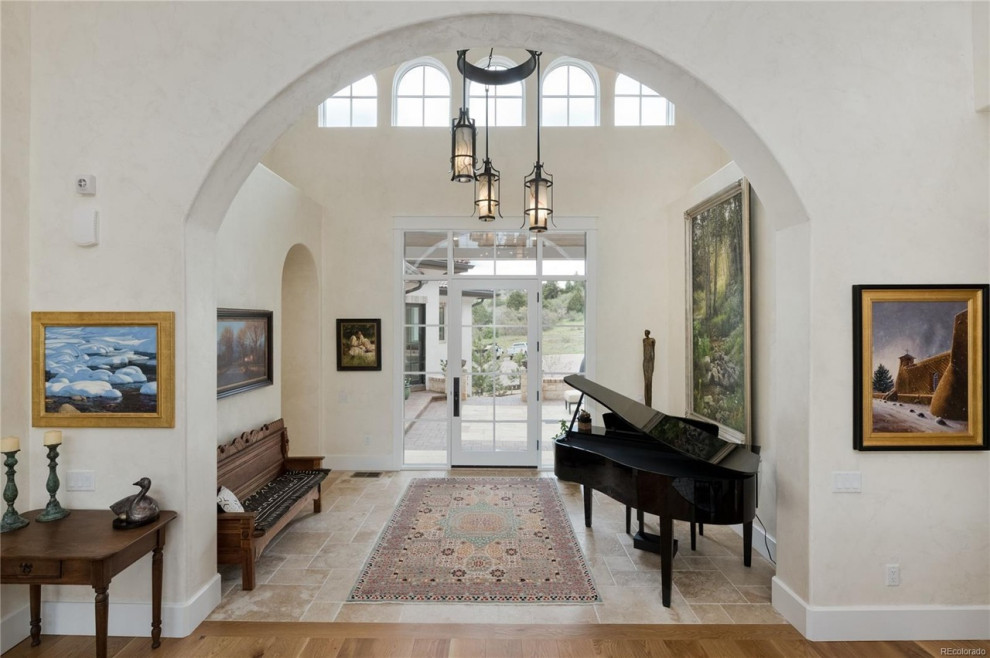 Photo of an entryway in Denver with travertine floors, grey floor and vaulted.