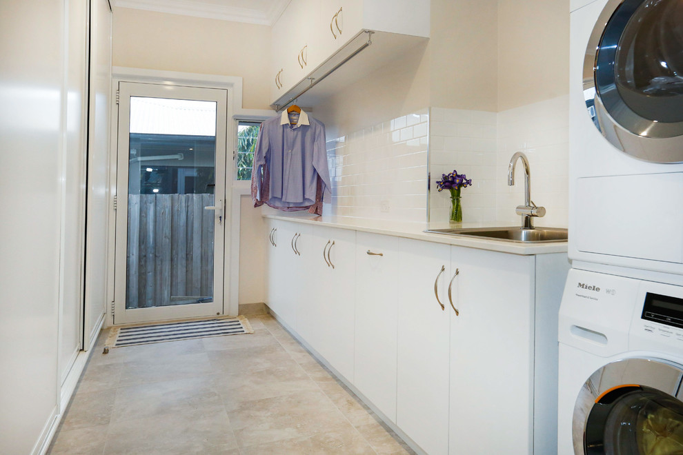 Traditional laundry room in Townsville with porcelain floors.