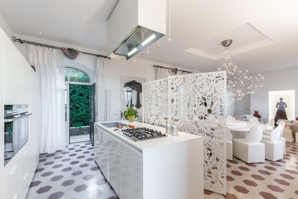 Photo of a contemporary galley open plan kitchen in Catania-Palermo with a drop-in sink, flat-panel cabinets, white cabinets, brown floor, white benchtop and with island.