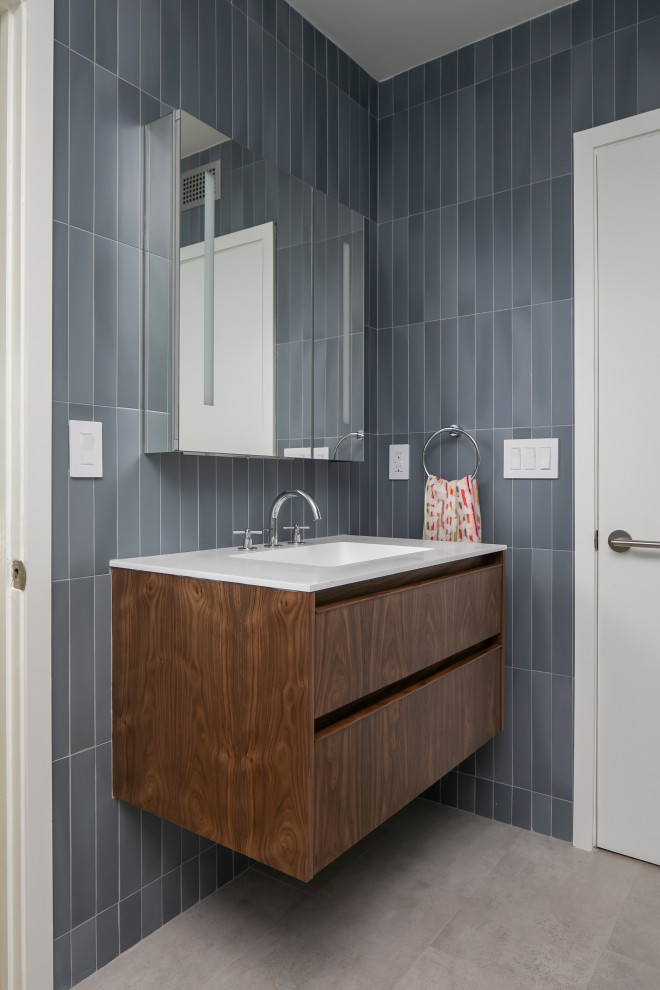 Design ideas for a medium sized midcentury ensuite bathroom in Los Angeles with flat-panel cabinets, medium wood cabinets, a freestanding bath, a corner shower, a bidet, blue tiles, ceramic tiles, blue walls, porcelain flooring, a wall-mounted sink, engineered stone worktops, grey floors, an open shower, white worktops, a single sink and a floating vanity unit.