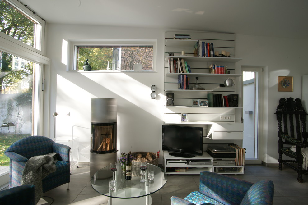 Inspiration for a contemporary family room in Dortmund with a wood stove and a metal fireplace surround.