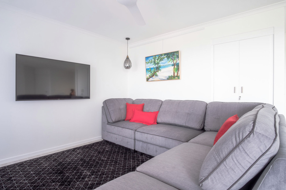 Small beach style open concept living room in Sunshine Coast with white walls, laminate floors, a wall-mounted tv and grey floor.