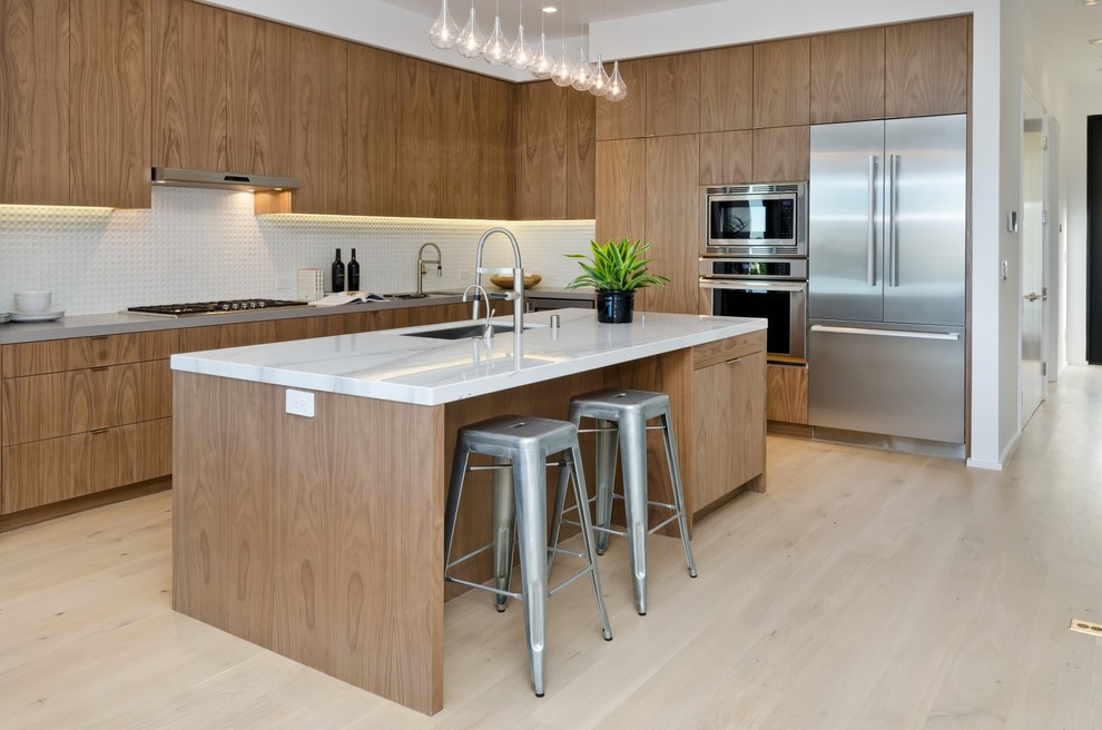 Photo of a large contemporary l-shaped eat-in kitchen in San Francisco with an undermount sink, flat-panel cabinets, medium wood cabinets, white splashback, stainless steel appliances, light hardwood floors, with island and quartz benchtops.