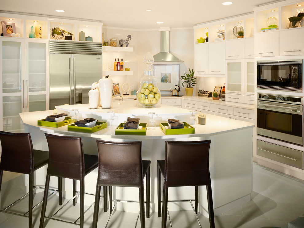 Design ideas for a mid-sized contemporary l-shaped eat-in kitchen in Tampa with flat-panel cabinets, white cabinets, stainless steel appliances, solid surface benchtops, concrete floors, with island and grey floor.