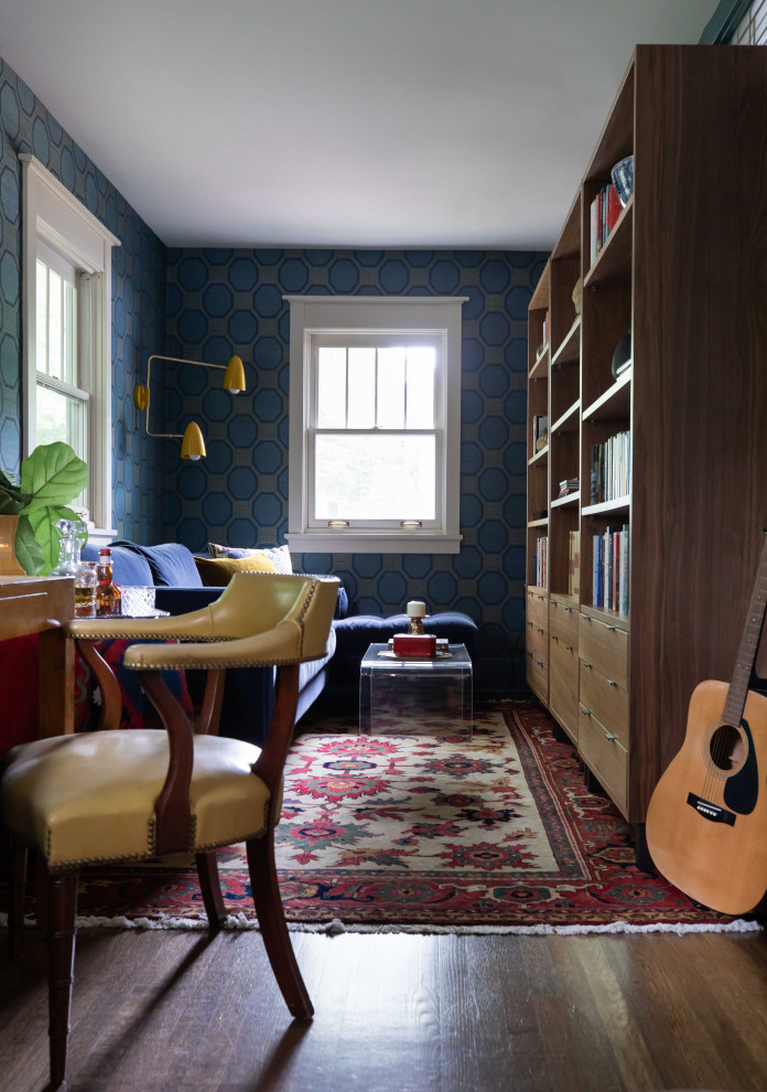 На фото: домашняя библиотека среднего размера в стиле фьюжн с синими стенами, паркетным полом среднего тона, отдельно стоящим рабочим столом, коричневым полом и обоями на стенах без камина с