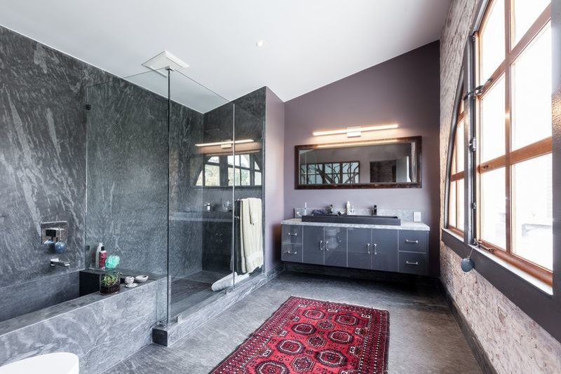 Photo of a mid-sized modern master bathroom in San Francisco with flat-panel cabinets, grey cabinets, a corner tub, a corner shower, grey walls, slate floors, a trough sink, solid surface benchtops, gray tile, grey floor and a hinged shower door.