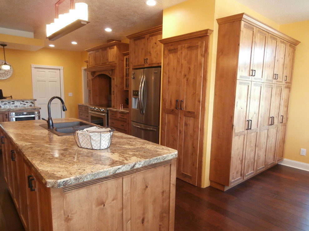 Example of a large mountain style single-wall eat-in kitchen design with a drop-in sink, shaker cabinets, medium tone wood cabinets, laminate countertops, metallic backsplash, stainless steel appliances and two islands