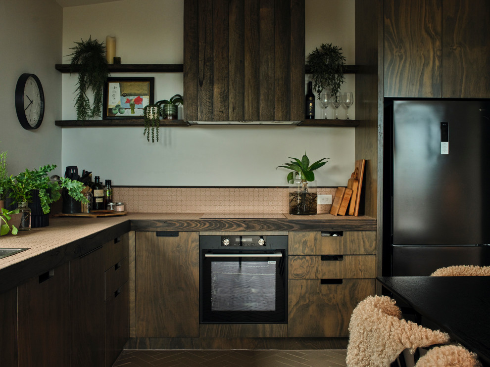 Immagine di una cucina minimal con lavello da incasso, ante lisce, ante in legno bruno, paraspruzzi rosa, paraspruzzi con piastrelle a mosaico, elettrodomestici neri, pavimento marrone e top rosa