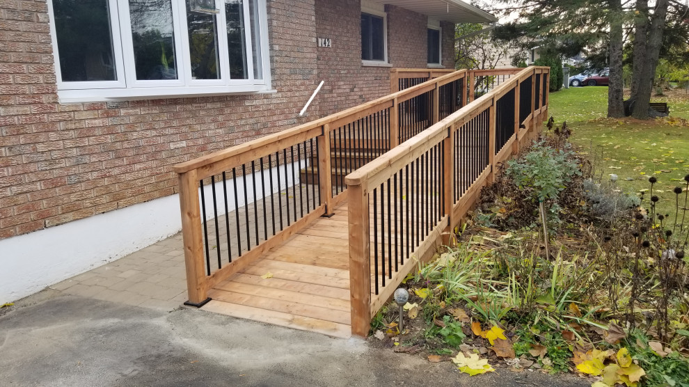 Photo of a mid-sized modern ground level deck in Ottawa with with skirting, no cover and mixed railing.