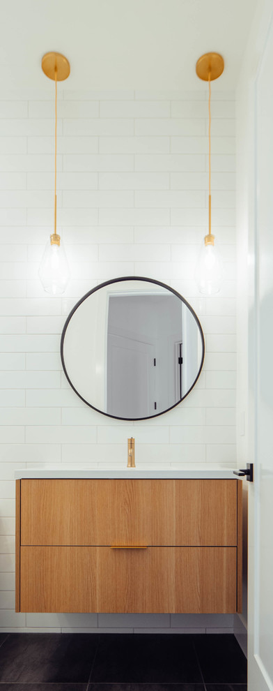 Mid-sized contemporary powder room in Sacramento with flat-panel cabinets, medium wood cabinets, a one-piece toilet, white tile, subway tile, white walls, porcelain floors, an undermount sink, engineered quartz benchtops, black floor and white benchtops.