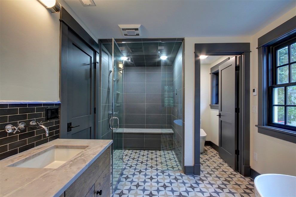 Design ideas for a transitional master bathroom in Cleveland with flat-panel cabinets, a curbless shower, a two-piece toilet, black tile, beige walls, cement tiles, an undermount sink, multi-coloured floor, a hinged shower door, beige benchtops and an enclosed toilet.