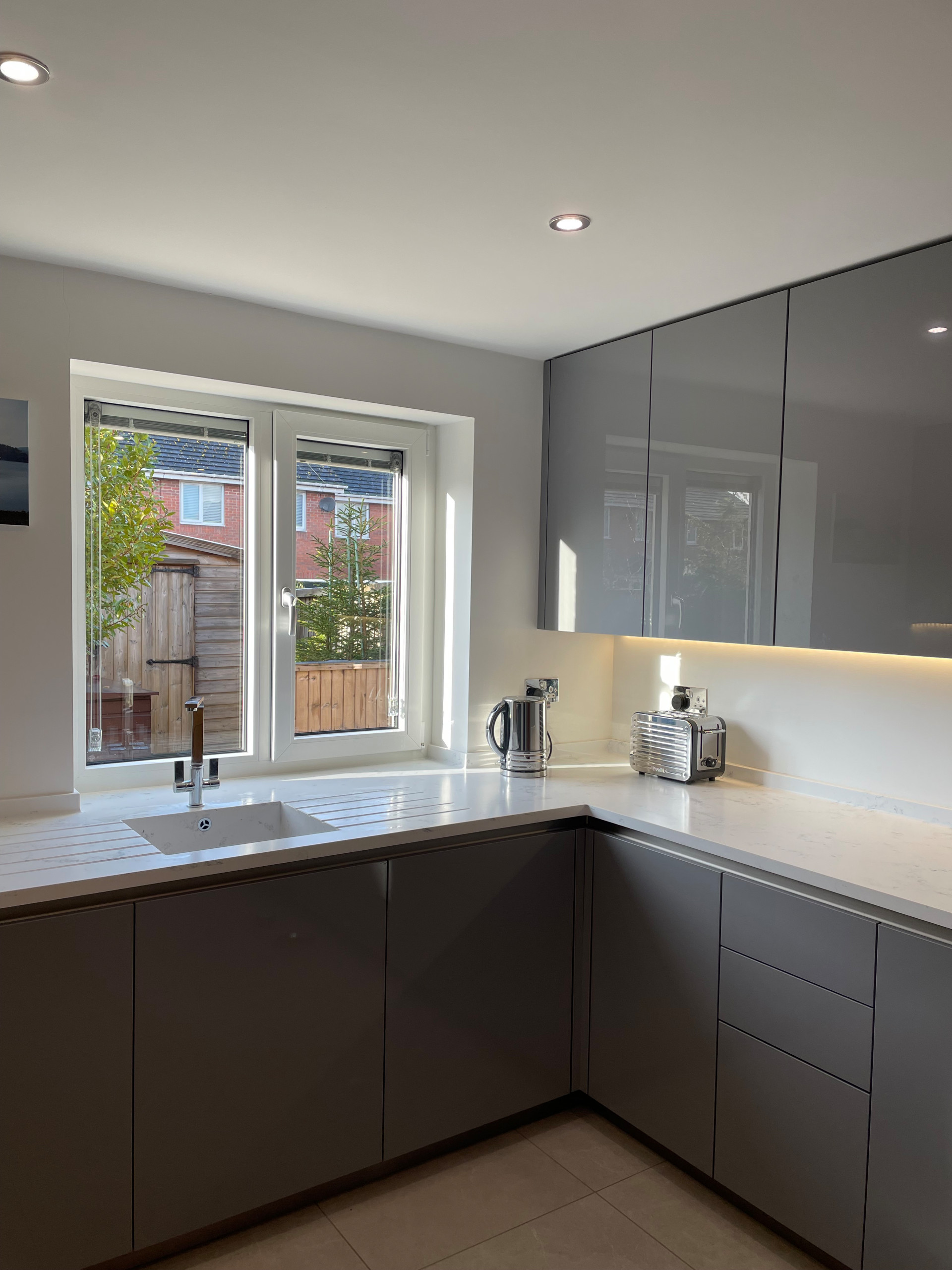 High Gloss Gravel Handleless Kitchen with White and Grey Solid Surface Tops