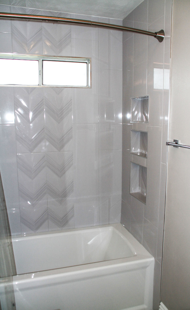 This is an example of a medium sized traditional family bathroom in Orange County with flat-panel cabinets, white cabinets, a built-in bath, a shower/bath combination, a one-piece toilet, grey tiles, porcelain tiles, grey walls, porcelain flooring, a submerged sink, engineered stone worktops, grey floors, an open shower and grey worktops.