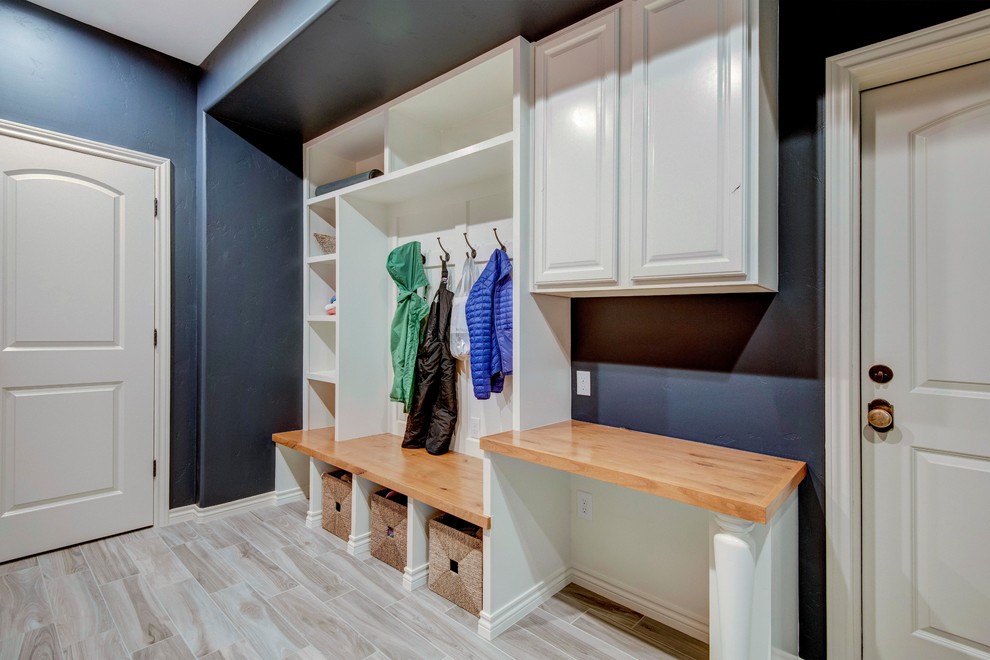 Photo of a mid-sized contemporary mudroom in Denver with blue walls, porcelain floors and beige floor.