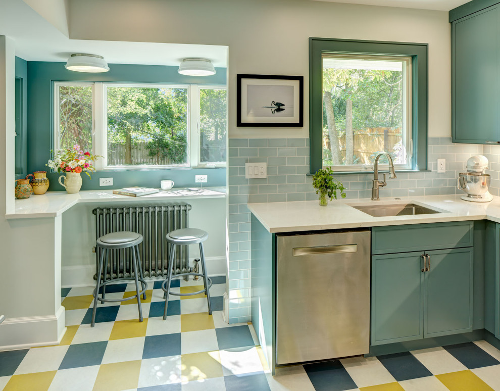 Foto på ett avskilt, litet vintage vit u-kök, med en undermonterad diskho, luckor med infälld panel, blå skåp, bänkskiva i kvarts, blått stänkskydd, stänkskydd i keramik, rostfria vitvaror, linoleumgolv och flerfärgat golv