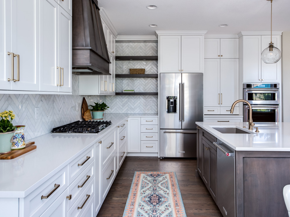Inspiration for a large transitional galley medium tone wood floor and brown floor open concept kitchen remodel in Denver with an undermount sink, shaker cabinets, white cabinets, quartz countertops, beige backsplash, marble backsplash, stainless steel appliances, an island and white countertops