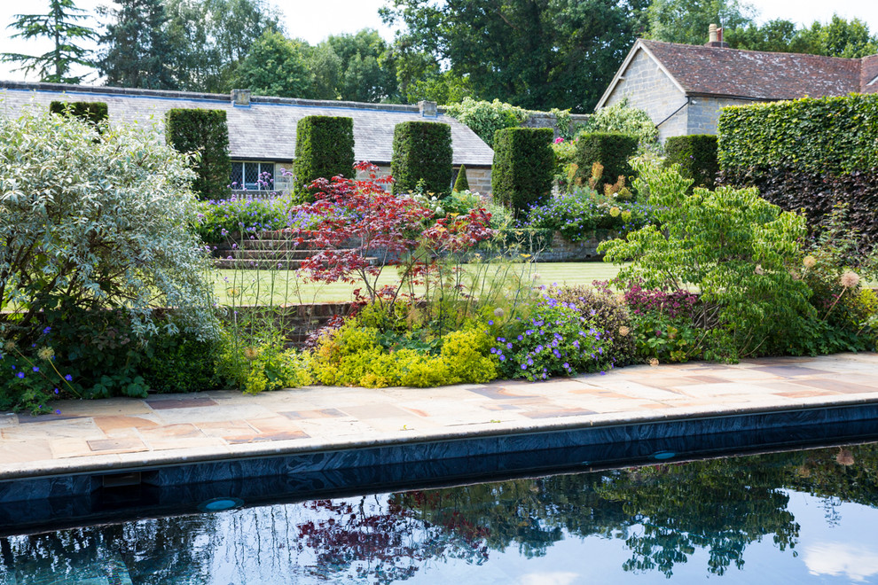 Design ideas for an expansive country backyard full sun formal garden for summer in Sussex with with pond and natural stone pavers.