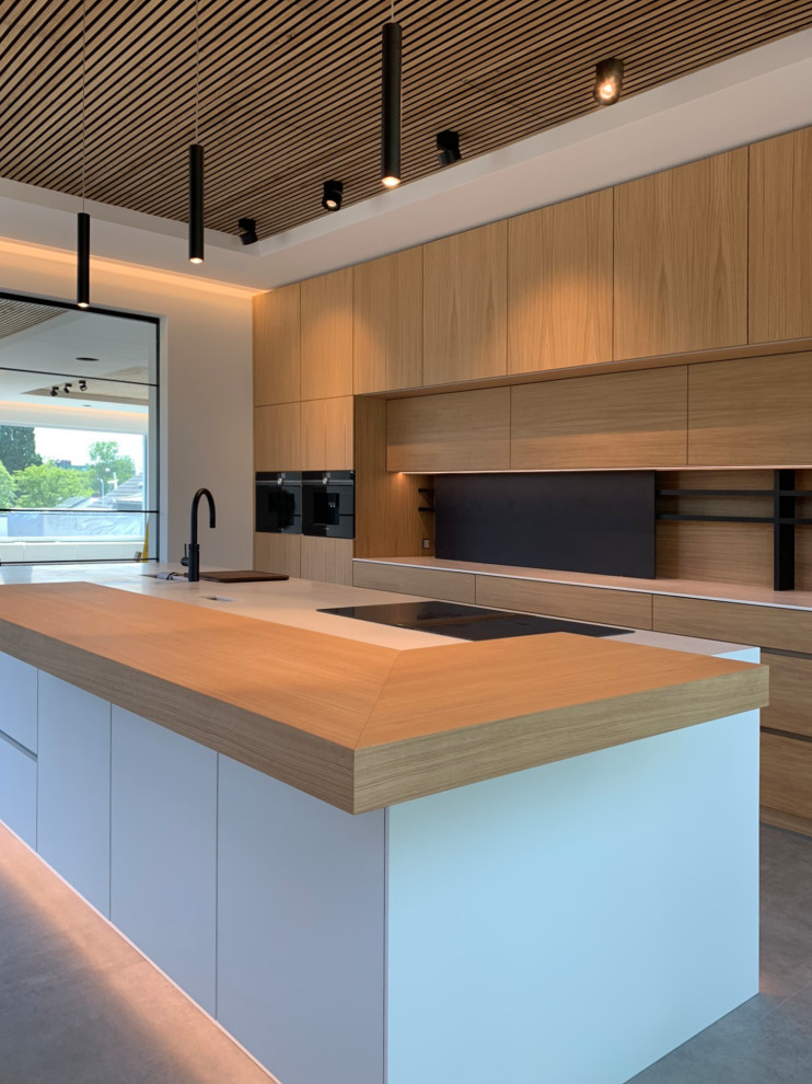 Design ideas for an urban kitchen in Essen with flat-panel cabinets, composite countertops, an island and white worktops.