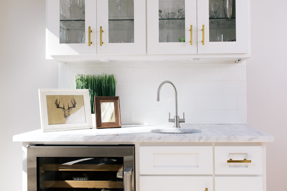Design ideas for a large transitional l-shaped eat-in kitchen in Atlanta with a farmhouse sink, shaker cabinets, yellow cabinets, marble benchtops, white splashback, ceramic splashback, stainless steel appliances, dark hardwood floors and with island.