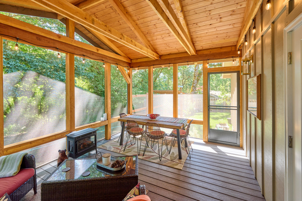 Exemple d'un porche d'entrée de maison arrière craftsman de taille moyenne avec une moustiquaire, une terrasse en bois, une extension de toiture et un garde-corps en bois.