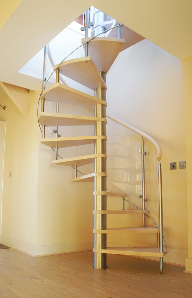 Photo of a mid-sized beach style wood spiral staircase in Hampshire with open risers.