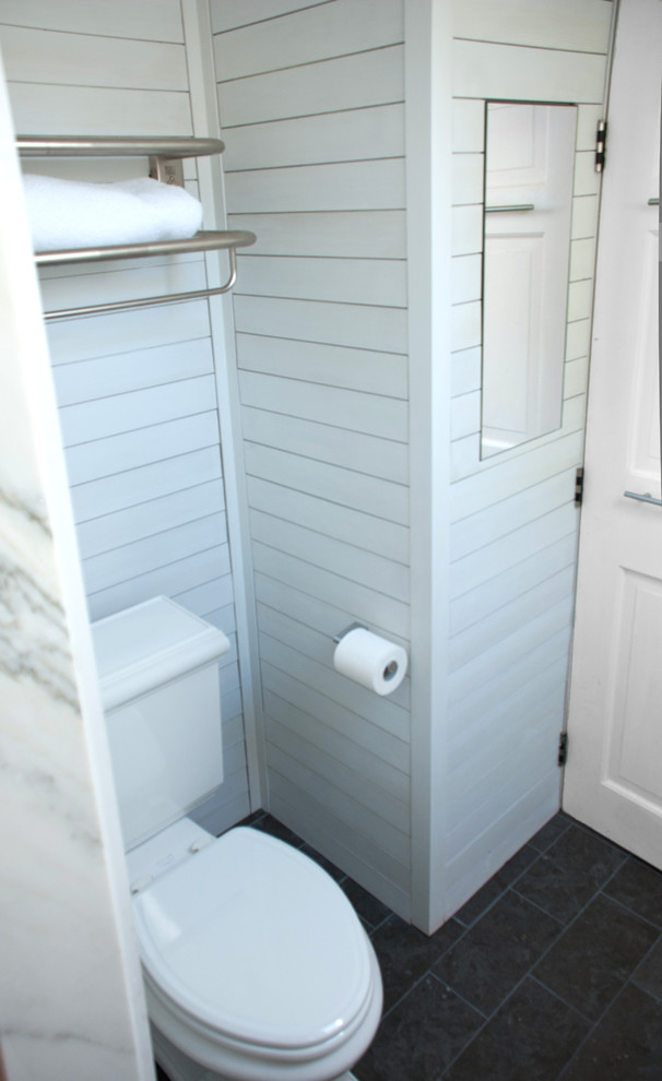 Mid-sized transitional kids' white tile and porcelain tile limestone floor alcove shower photo in Boston with a trough sink, furniture-like cabinets, white cabinets, quartz countertops, a one-piece toilet and white walls