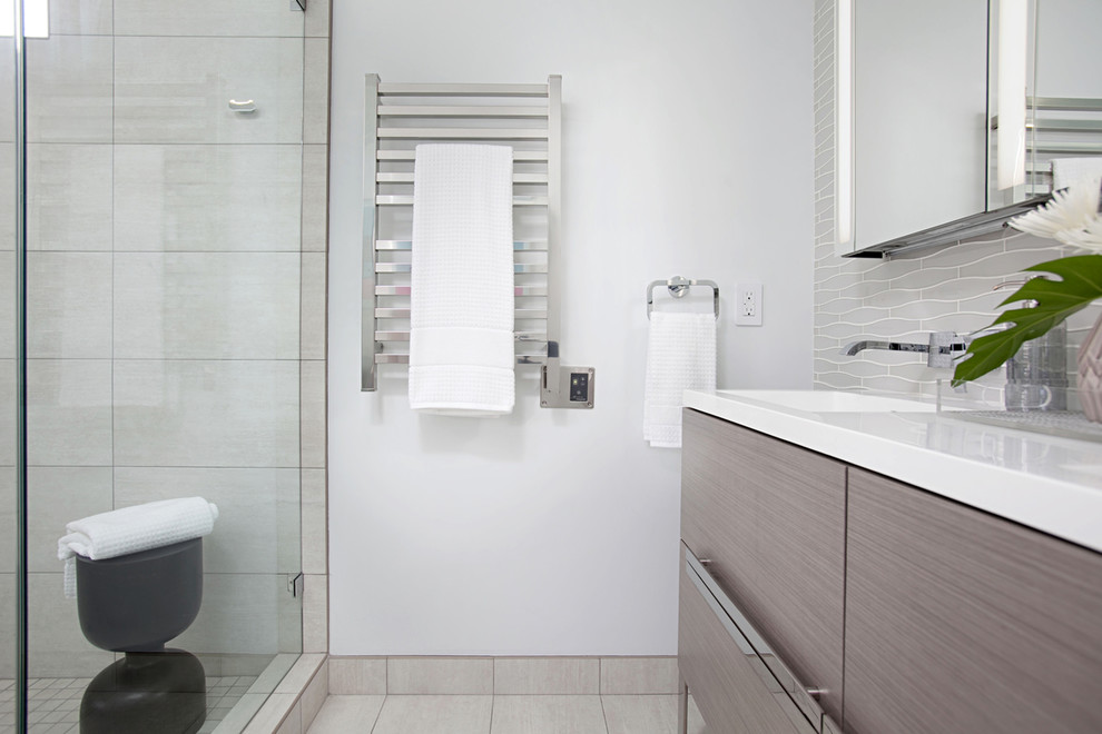 Design ideas for a mid-sized modern master bathroom in San Diego with flat-panel cabinets, grey cabinets, a corner shower, a bidet, white tile, glass tile, blue walls, ceramic floors, an integrated sink, quartzite benchtops, grey floor and a hinged shower door.