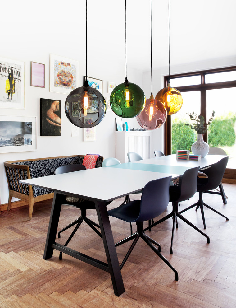 Design ideas for a mid-sized contemporary open plan dining in Wiltshire with white walls and medium hardwood floors.