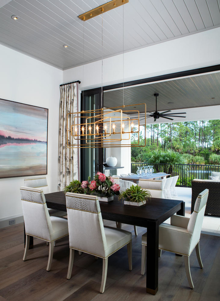 Transitional dining room in Miami with white walls, dark hardwood floors and brown floor.