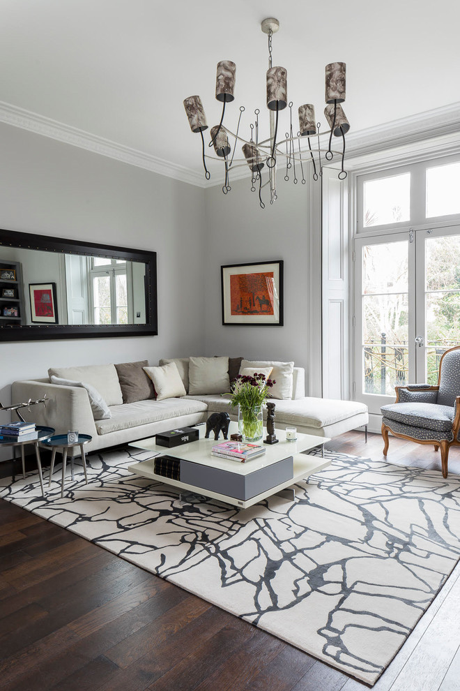 This is an example of a contemporary formal enclosed living room in London with grey walls, dark hardwood floors and brown floor.