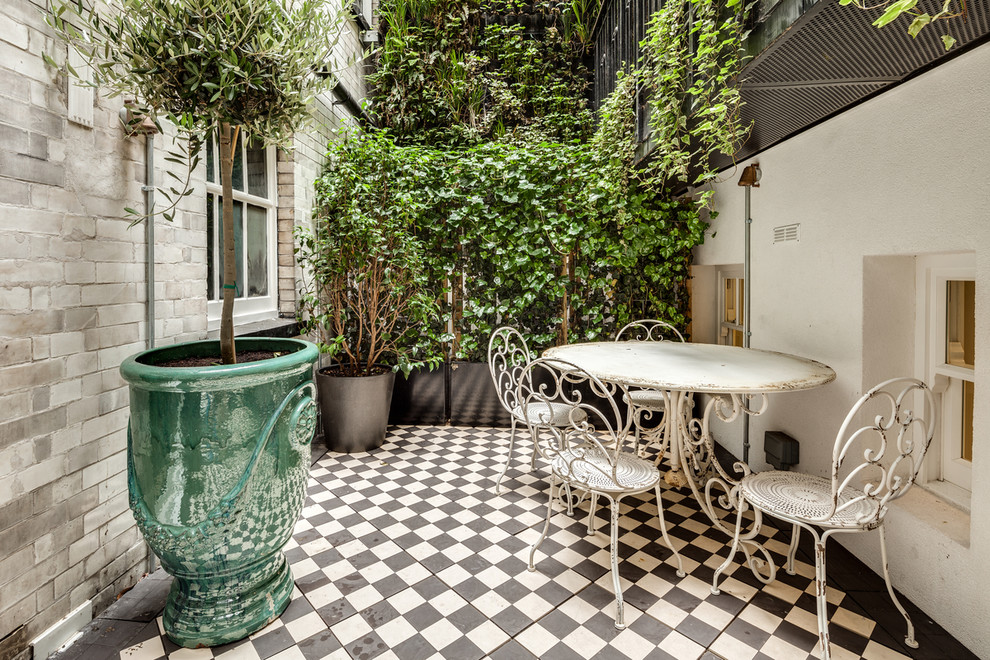 Small transitional courtyard patio in London with a vertical garden.