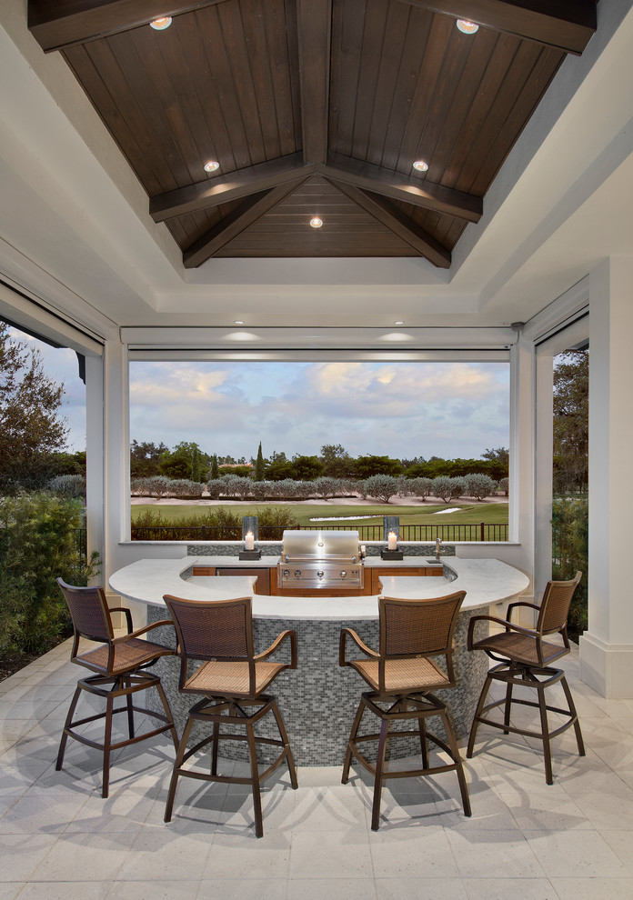 Inspiration for a large transitional backyard deck in Miami with an outdoor kitchen and a roof extension.