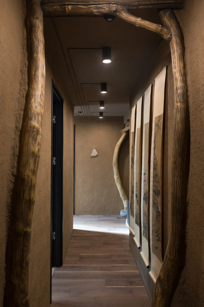 Mid-sized asian hallway in Los Angeles with beige walls, dark hardwood floors and brown floor.